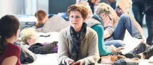 Geselliges Beisammensein. Passagiere auf Feldbetten im Frankfurter Flughafen. 