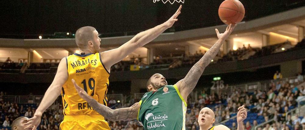 Malagas Marcus Williams (M.) bei einem Korbleger gegen Berlins Albert Miralles (l.) und Zach Morley (r).