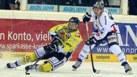 Bloß nicht den Halt verlieren. Krefelds Kevin Orendorz (l.) spielt den Puck im Fallen vor Mark Katic.
