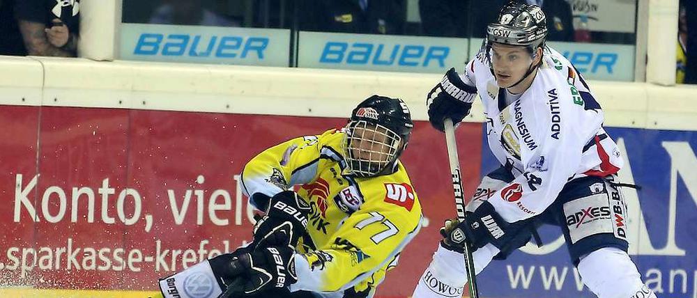Bloß nicht den Halt verlieren. Krefelds Kevin Orendorz (l.) spielt den Puck im Fallen vor Mark Katic.