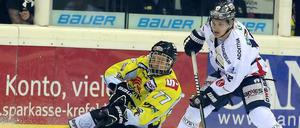 Bloß nicht den Halt verlieren. Krefelds Kevin Orendorz (l.) spielt den Puck im Fallen vor Mark Katic.