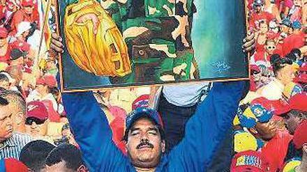 Nicolás Maduro will Präsident werden. Dafür hält er ein Plakat des verstorbenen Präsidenten Hugo Chávez hoch. In den Umfragen liegt der ehemalige Busfahrer vorn. Foto: AFP