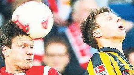 Gleichstand auch in der Luft. Unions Mittelfeldspieler Michael Parensen (links) und der Dresdner Tobias Jänicke kämpfen um den Ball. Foto: dpa