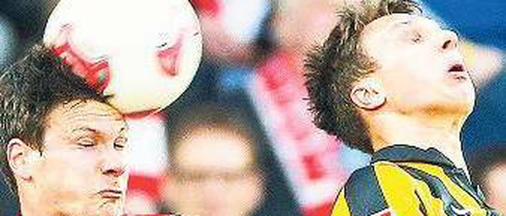 Gleichstand auch in der Luft. Unions Mittelfeldspieler Michael Parensen (links) und der Dresdner Tobias Jänicke kämpfen um den Ball. Foto: dpa