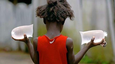 Ein Mädchen in Monrovia mit den beliebten Wasserpacks, die auf der Straße verkauft werden.