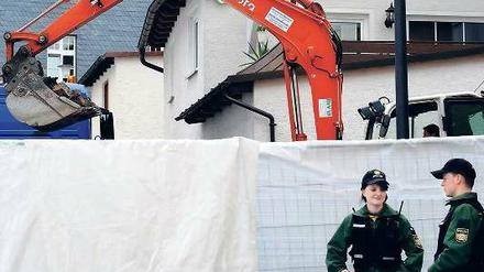 Hinter einer Plane gräbt ein Bagger nach dem verschwundenen Leichnam. Foto: dpa
