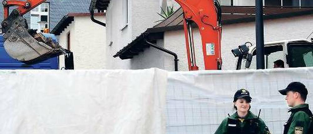 Hinter einer Plane gräbt ein Bagger nach dem verschwundenen Leichnam. Foto: dpa