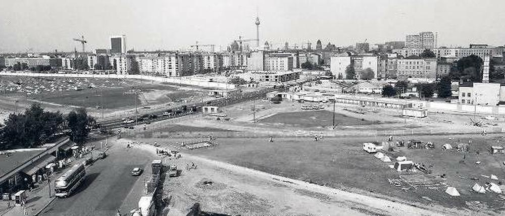 Brachland. Das Lenné-Dreieck lag nordwestlich des Potsdamer Platzes. Das Foto zeigt den Platz im Jahr 1990, mit dem Dreieck am linken Bildrand und im Vordergrund der Versuchsstrecke der Magnetbahn.