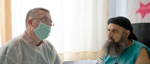 Markus Löning (links) erkundigt sich bei Eitham al Abud, einem der 36 Schwerverletzten Syrer, die in Deutschland behandelt werden, nach der Situation im Bürgerkriegsland.