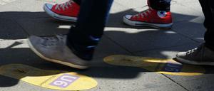 Aufkleber in Form von Schuhabdrücken weisen in der Friedrichstraße - Ecke Unter den Linden in Berlin zum U-Bahnhof und S-Bahnhof Friedrichstraße.