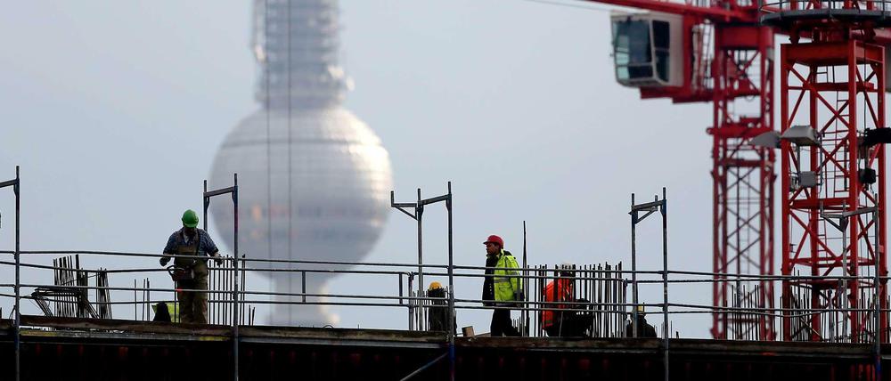 Arbeiter auf der Baustelle in der Nähe des Alexanderplatzes, wo ein weiteres Kaufhauskomplex entstehen soll.