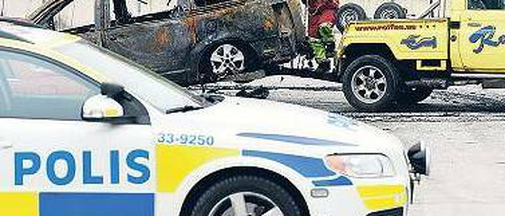 Spuren der Ausschreitungen: Ein ausgebranntes Auto im Vorort Husby. Foto: AFP