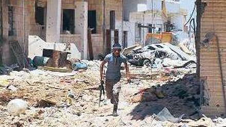 Deckung suchen. Ein Rebell in der zum Teil zerstörten Stadt Daraa. Foto: AFP