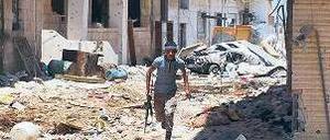 Deckung suchen. Ein Rebell in der zum Teil zerstörten Stadt Daraa. Foto: AFP