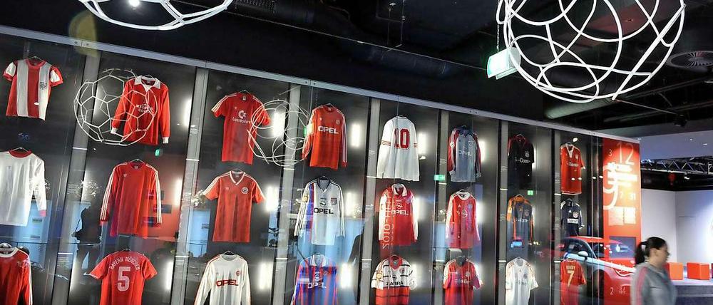 Eine Vitrine mit Bayerntrikots verschiedener Spielzeiten.