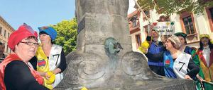 Ohne Kontra und Re reinigen die Teilnehmer des „lebenden Skatspiels“ den Skatbrunnen in Altenburg. Die Stadt feiert „200 Jahre Skat“.