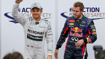 Nico Rosberg und Sebastian Vettel stehen vor Fotografen.