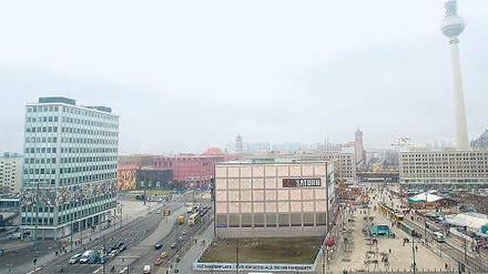 Hier soll es hin: Das erste Hochhaus am Alex soll nahe dem beige-grauen Gebäude des Elektronikmarkts entstehen.