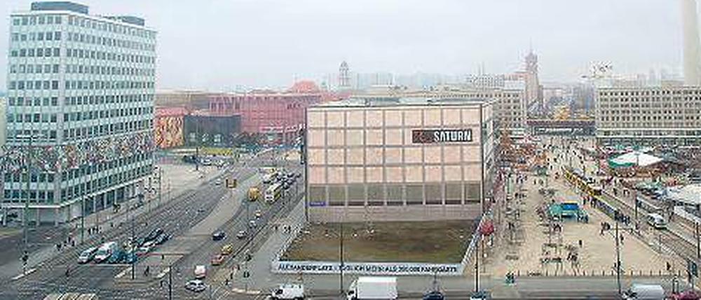 Hier soll es hin: Das erste Hochhaus am Alex soll nahe dem beige-grauen Gebäude des Elektronikmarkts entstehen.