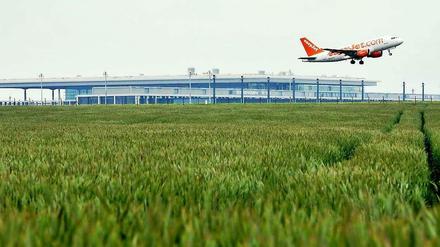 Eine Maschine der Fluglinie Easyjet passiert in Berlin während der Startphase das neue Terminal des Flughafens BER in Schönefeld (Brandenburg). 