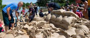 Freiwillige Helfer schichten Sandsäcke aufeinander - Zivilcourage in Sachsen