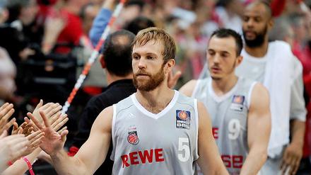 Die Bamberger John Goldsberry (v. l. n. r.), Karsten Tadda und Sharrod Ford klatschen nach dem 98:79-Sieg mit den Fans ab.