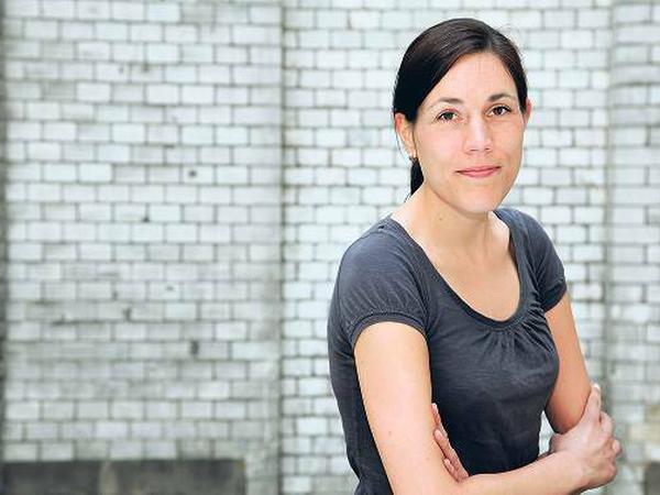 Junge Frau mit dunklen Haaren im grauen T-shirt.