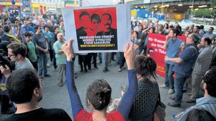 Protest und Gedenken. Bei der Demonstration in Kreuzberg hält eine Frau ein Plakat mit Bildern von bei den Protesten in Istanbul Getöteten in die Höhe.