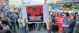 Protest und Gedenken. Bei der Demonstration in Kreuzberg hält eine Frau ein Plakat mit Bildern von bei den Protesten in Istanbul Getöteten in die Höhe.