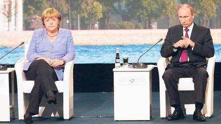 Gute Laune sieht anders aus. Angela Merkel und Wladimir Putin saßen am Freitag beim Petersburger Wirtschaftsforum gemeinsam auf dem Podium. Anschließend bemühten sie sich um eine Schlichtung des Streits um die Beutekunst. Foto: Anatoly Maltsev/dpa