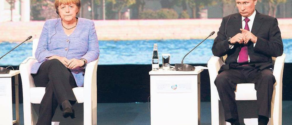 Gute Laune sieht anders aus. Angela Merkel und Wladimir Putin saßen am Freitag beim Petersburger Wirtschaftsforum gemeinsam auf dem Podium. Anschließend bemühten sie sich um eine Schlichtung des Streits um die Beutekunst. Foto: Anatoly Maltsev/dpa