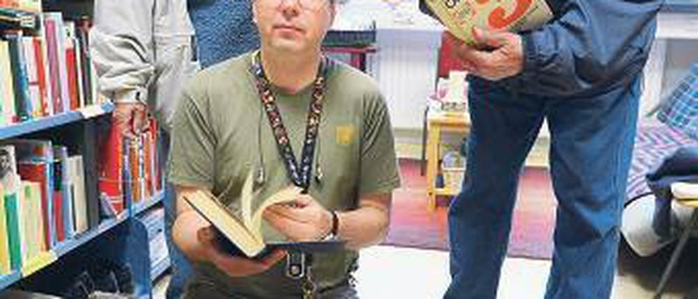 Aus zweiter Hand. Volker Schmidt, 34, Elektrotechniker aus Charlottenburg (Bildmitte), mit den Bücherspendern Rita und Heinz Rahnenführer.