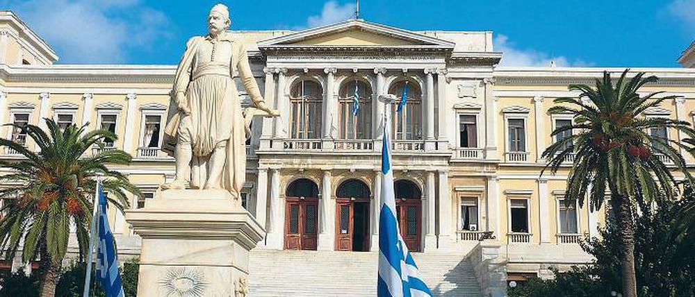 Auf Marmor gebaut. Das neoklassizistische Rathaus von Ermoupoli wurde vom Deutschen Ernst Ziller geplant. Im Vordergrund die Statue des Freiheitskämpfers Miaoulis.