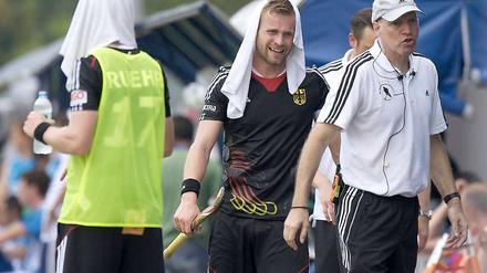 Da war es noch heiß. Deutschlands Christopher Rühr (l-r) und Maximilian Müller tragen am Spielfeldrand nasse Handtücher gegen die Hitze auf dem Kopf neben Bundestrainer MarkusWeise. 
