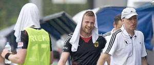 Da war es noch heiß. Deutschlands Christopher Rühr (l-r) und Maximilian Müller tragen am Spielfeldrand nasse Handtücher gegen die Hitze auf dem Kopf neben Bundestrainer MarkusWeise.