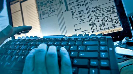 Hände über einer Computertastatur im Schummerlicht