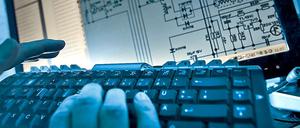 Hände über einer Computertastatur im Schummerlicht