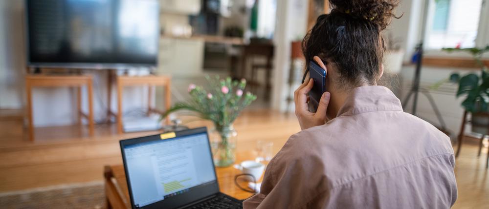 Eine junge Frau lässt sich am Telefon beraten.