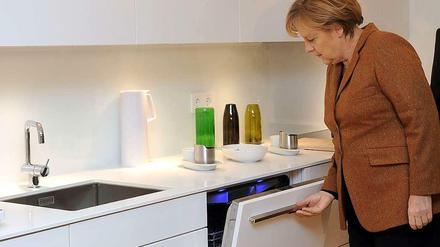 Was es nicht alles gibt! Bundeskanzlerin Angela Merkel (CDU) blickt in Berlin in einem Energieeffizienzhaus hinter die Kulissen. 