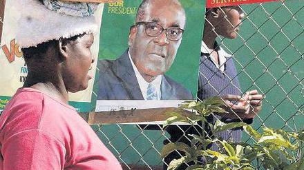 Ruhe vor dem Wahltag: In Simbabwes Hauptstadt Harare hängen Plakate von Staatschef Mugabe und seinem Herausforderer Tsvangirai (rechts). Foto: Philimon Bulawayo/Reuters