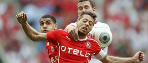 Zweikampf ohne Sieger: Kölns Thomas Bröker (r.) versucht gegen Düsseldorfs Andreas Lambertz an den Ball zu kommen, Leon Balogun (l.) schaut zu. 