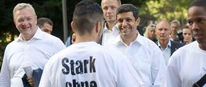 CDU-Innensenator Frank Henkel (li.) und SPD-Fraktionschef Raed Saleh (Mitte) auf Kiezstreife mit Jugendlichen. 