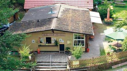 Vom Aussichtsturm fällt der Blick auf die Gaststätte in Hessen. Rechts unten neben der Bank steht der Grenzstein zu Niedersachsen.