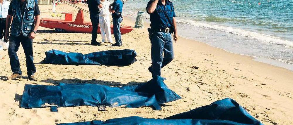 Leichen am Strand von Catania. Die ostsizilianische Stadt am Fuße des Ätna war bislang kein Anlaufpunkt für Schlepperboote aus Nordafrika. Italien versucht seit Jahren, den Flüchtlingsstrom aus dem Mittelmeer in den Griff zu bekommen. Foto: Dario Azzaro/AFP