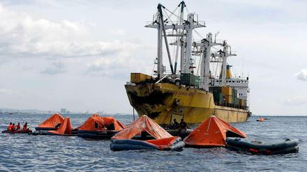 Helfer suchen im Wasser nach vermissten Passagieren.