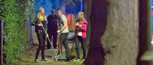 Die Partygäste kehren ihre Scherben zusammen.