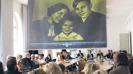Zeitzeugen sitzen in einem Saal und berichten über den Zweiten Weltkrieg.