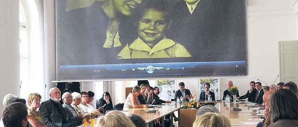 Zeitzeugen sitzen in einem Saal und berichten über den Zweiten Weltkrieg.