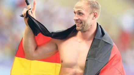 Na, mitgezählt? Robert Harting zeigt noch einmal an, wie oft er den WM-Titel mittlerweile gewonnen hat.