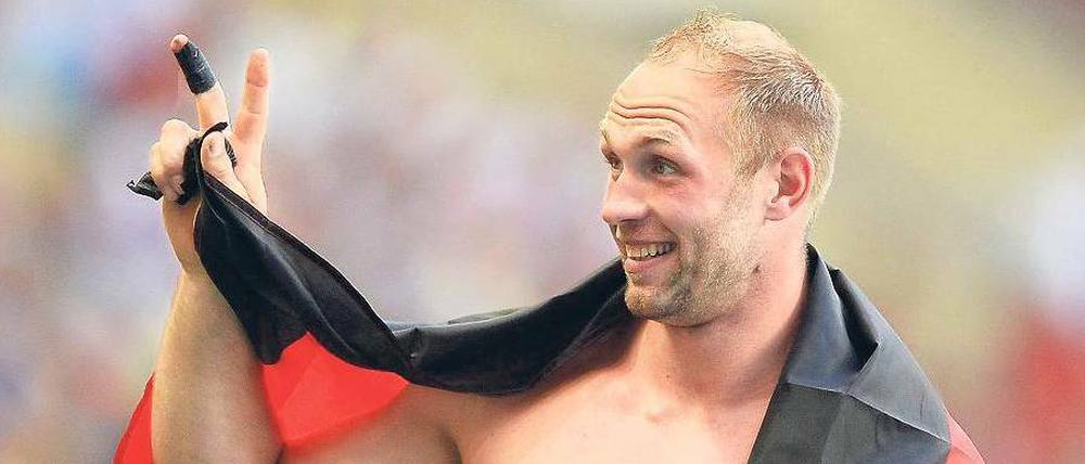Na, mitgezählt? Robert Harting zeigt noch einmal an, wie oft er den WM-Titel mittlerweile gewonnen hat.